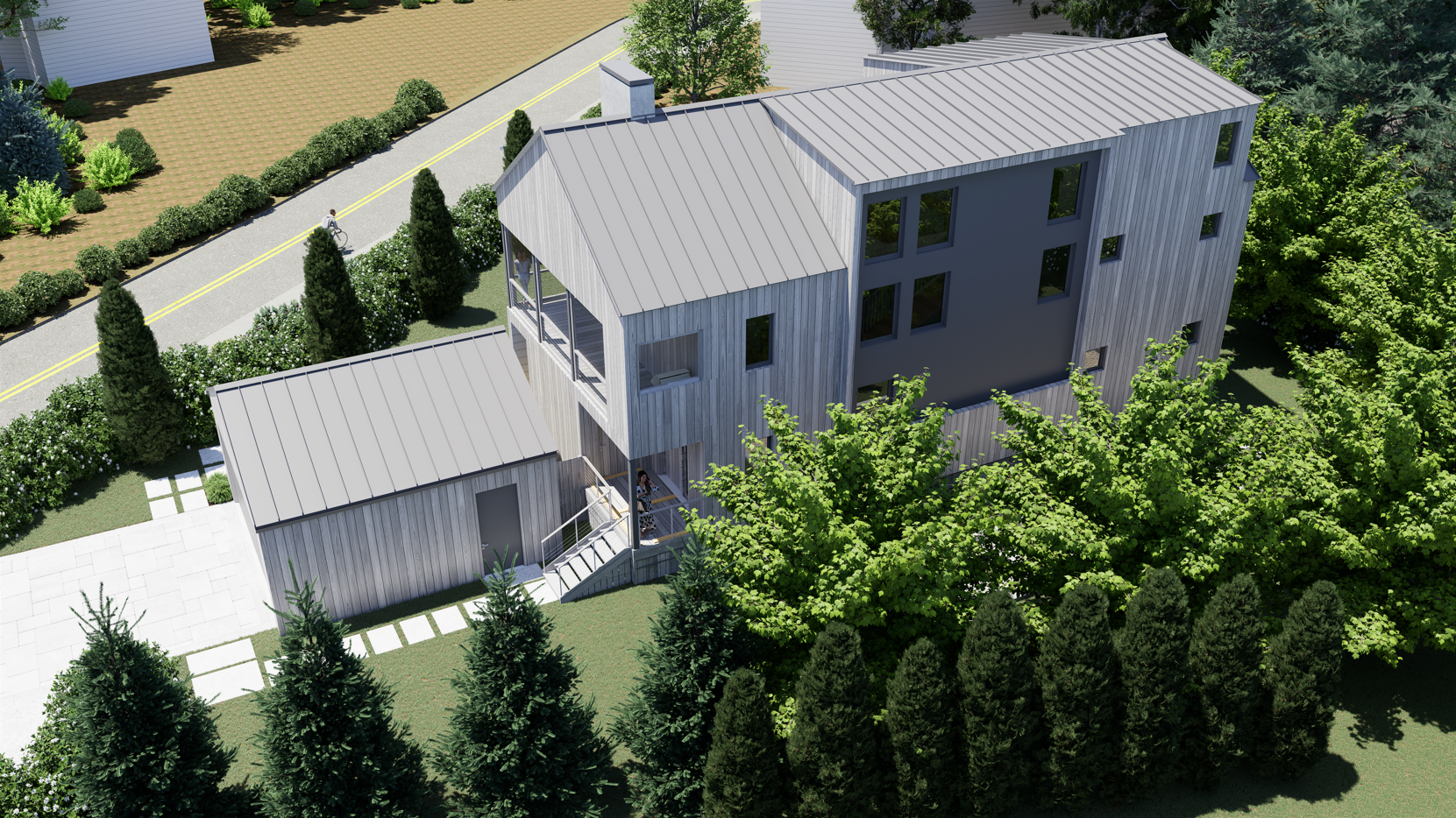 Aerial view of a modern two-story home featuring vertical weathered grey wood siding, a standing-seam metal roof, a covered porch with an exterior staircase, and lush surrounding trees and landscaping.