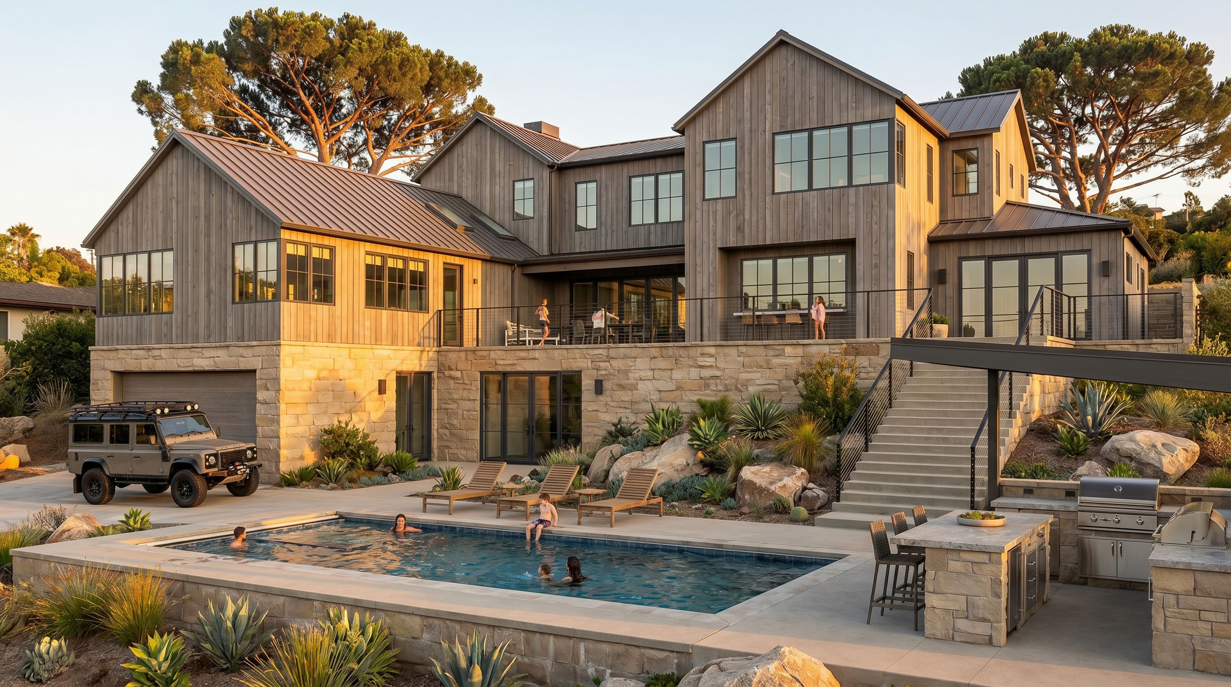 A large modern farmhouse-style home with vertical wood siding and a stone lower level, featuring an expansive elevated deck, an outdoor pool, lounge chairs, and an outdoor kitchen area.