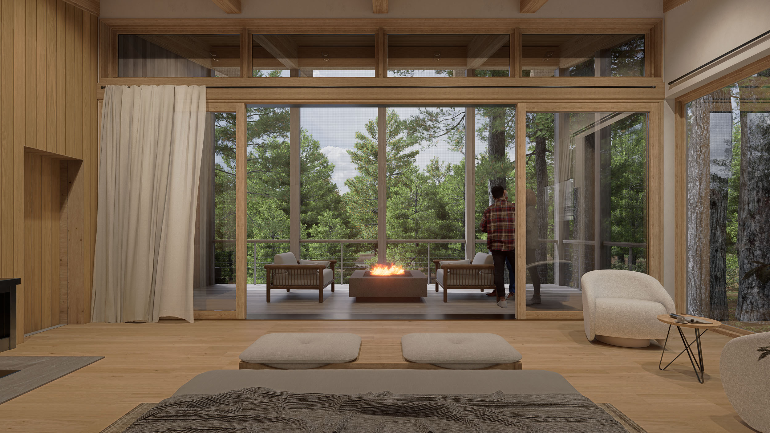 This modern interior features expansive sliding glass doors that open onto an elevated outdoor deck framed by lush trees. The deck is furnished with comfortable armchairs and a central fire pit table, while two people stand looking out. Inside, the room has light wood flooring, warm wood-paneled walls, minimalist seating, and a large window looking out to the forest.
